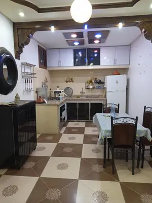 a large kitchen with a table and a table and a table and chairs at El farah in Oulad Akkou