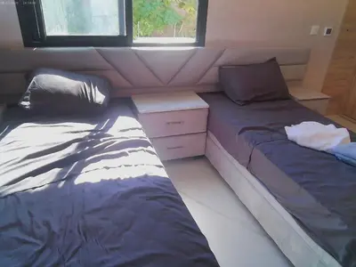 a bedroom with two beds and a dresser in it at Villa Ghmat in Aït Ali Ou Allah