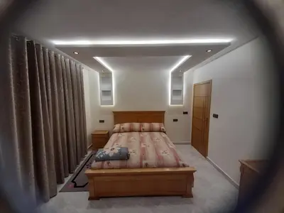 a bedroom with a large bed and curtains at diki ksar sghir in Oulad Akkou
