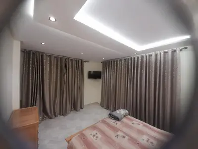 a bedroom with a bed and curtains and a television at diki ksar sghir in Oulad Akkou