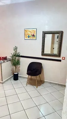 a chair sitting in a room with a mirror at Aéroport Service navette vers logement cosy in Oulad Akkou