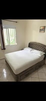 a large bed in a bedroom with a window at Aéroport Service navette vers logement cosy in Oulad Akkou
