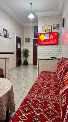 a living room with a couch and a television on the wall at Aéroport Service navette vers logement cosy in Oulad Akkou