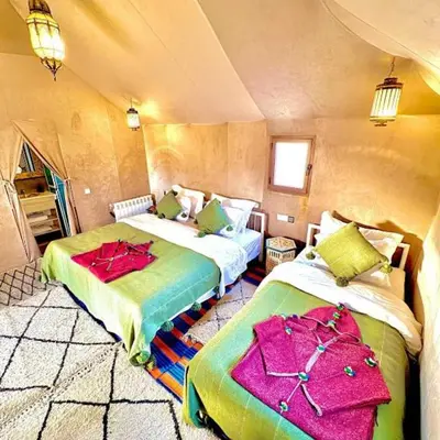 a bedroom with two beds in a room at One Thousand and One Night Luxury Camp in Merzouga