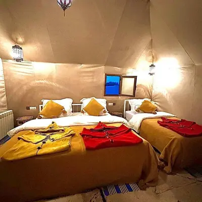 a bedroom with two beds in a room at One Thousand and One Night Luxury Camp in Merzouga