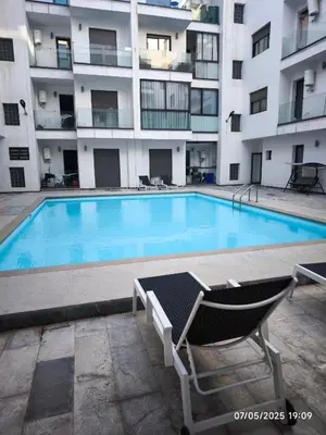 a swimming pool in front of a apartment building at Appartement agadir bay bien ensoleillé in Oulad Akkou
