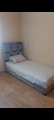 a bed with a blue headboard in a room at Apartamento en Rabat al lado del Mar in Oulad Akkou