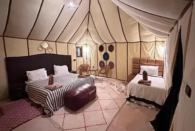 a bedroom with two beds in a tent at Fantastic desert camp in Oulad Akkou
