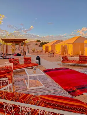a group of tents in the middle of the desert at Merzouga heritage camp in Merzouga