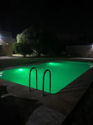 a swimming pool with green illumination at night at Villa cherif in Chouiter