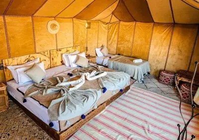 a room with two beds in a tent at Sahara Luxurious Tented in Merzouga