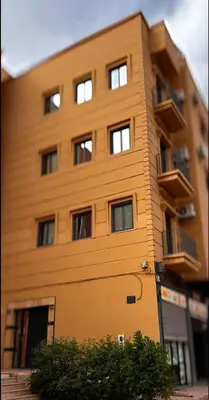 a tall building with windows on the side of it at Relax Family 06 - Cozy Studio in City Center in Ouarzazate