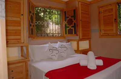 a bedroom with a bed with white pillows and a window at Bab Jbel in Ourika