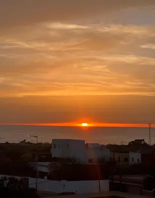a sunset over the ocean with the sun in the sky at Apartment for rent by the day in Oulad Akkou