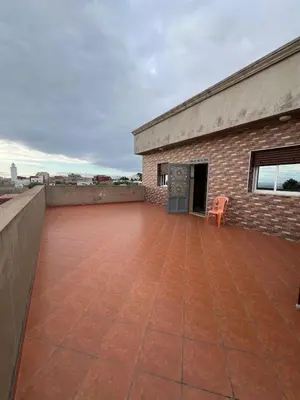 a patio with a chair on top of a building at Apartment for rent by the day in Oulad Akkou