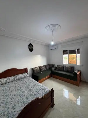 a bedroom with a bed and a couch at Apartment for rent by the day in Oulad Akkou