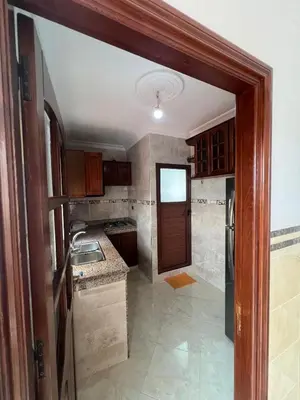 an empty kitchen with a door open to a room at Apartment for rent by the day in Oulad Akkou
