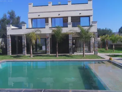a house with a swimming pool in front of a house at Villa GHMAT in Aghmat