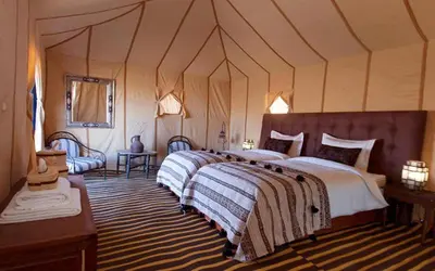 a bedroom with a large bed in a tent at Merzouga Starluxe Camp in Merzouga