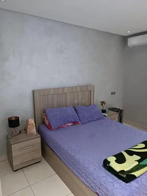 a bedroom with a large bed with purple sheets at Appartement hay mohammadi GH26 in Oulad Akkou