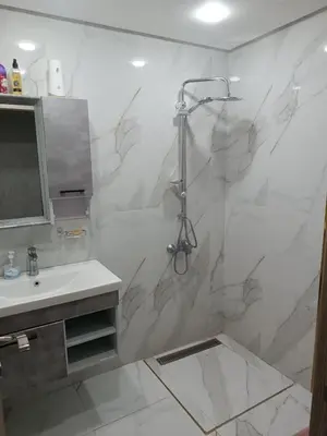 a white bathroom with a shower and a sink at Appartement hay mohammadi GH26 in Oulad Akkou