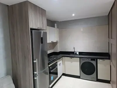a small kitchen with a stainless steel refrigerator at Appartement hay mohammadi GH26 in Oulad Akkou