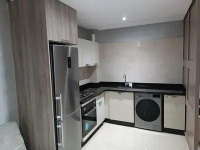 a kitchen with a stainless steel refrigerator and a dishwasher at Appartement hay mohammadi GH26 in Oulad Akkou