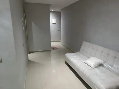 a living room with a white couch in a room at Appartement hay mohammadi GH26 in Oulad Akkou