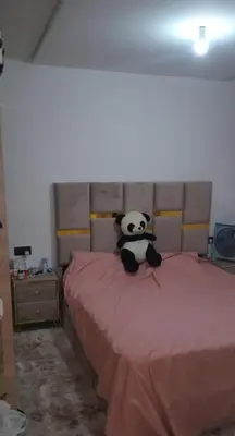 a panda bear sitting on top of a bed at شقة مريحه in Oulad Akkou