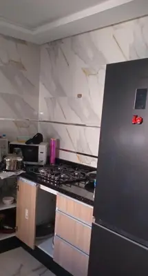 a kitchen with a refrigerator and a counter top at شقة مريحه in Oulad Akkou