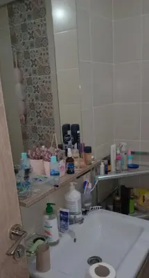 a bathroom with a sink and a large mirror at شقة مريحه in Oulad Akkou