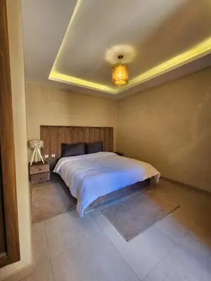 a bedroom with a large bed with a ceiling at Appartement de Pause Intérieure in Oulad Akkou