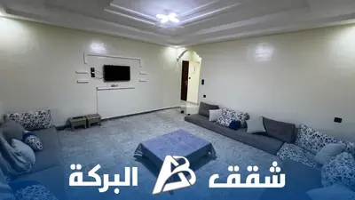 a living room with a couch and a tv at Appartements Al Baraka in Oulad Akkou