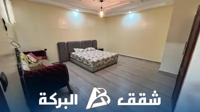 a room with a bed and a chair in it at Appartements Al Baraka in Oulad Akkou