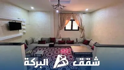 a living room with a couch and a tv at Appartements Al Baraka in Oulad Akkou