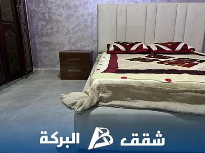a bedroom with a bed with a blanket on it at Appartements Al Baraka in Oulad Akkou