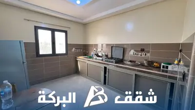 a small kitchen with a counter and a window at Appartements Al Baraka in Oulad Akkou