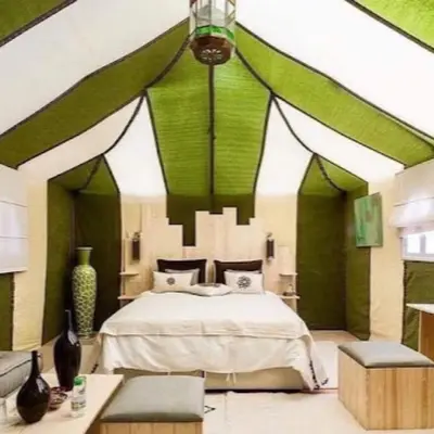 a bedroom with a bed with green and white walls at Luxury camps merzouga in Merzouga