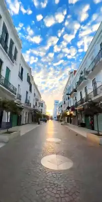 an empty street with buildings and a cloudy sky at The White House Tetouan in Oulad Akkou