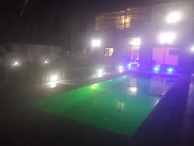 a house with a swimming pool at night with lights at charmante villa à découvrir in Aghmat