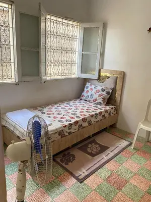 a small bedroom with a bed and a fan at Dar dyafa in Fès