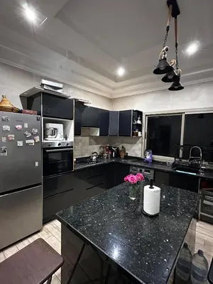 a kitchen with black cabinets and a black counter top at Villa avec piscine in Meknès