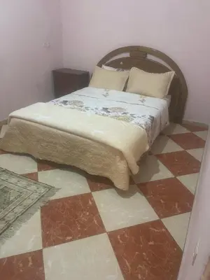 a bedroom with a bed on a checkered floor at hôtel kawtar in Meknès