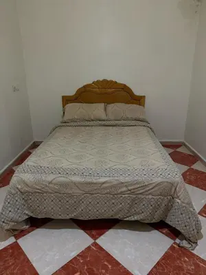 a bed sitting in a bedroom with a tiled floor at hôtel kawtar in Meknès