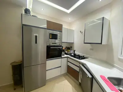 a kitchen with a stainless steel refrigerator and microwave at Bel appartement à louer in Ifrane