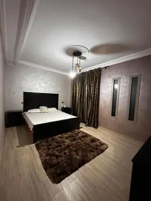 a bedroom with a large bed and a rug at Villa élégante in Aït Ali Ou Moussa
