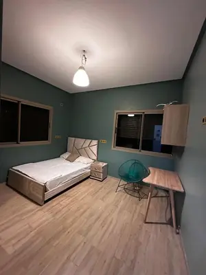 a bedroom with a bed and a table and windows at Villa élégante in Aït Ali Ou Moussa