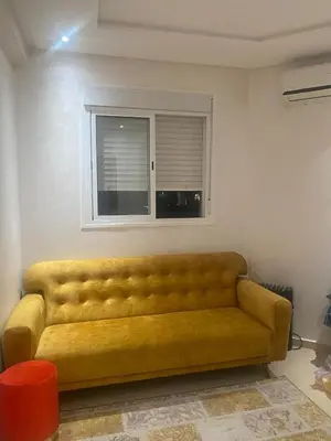 a yellow couch in a living room with a window at Appartement luxueux in Ifrane