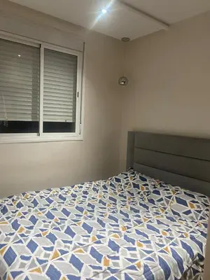a bedroom with a blue and white bed with a window at Appartement luxueux in Ifrane