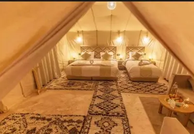 a attic bedroom with two beds and a rug at Merzouga Lovely Luxury Camp in Merzouga